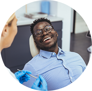 Man in the dental chair smiling at his dentist