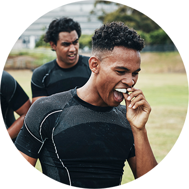 Soccer playing putting a mouthguard over his teeth